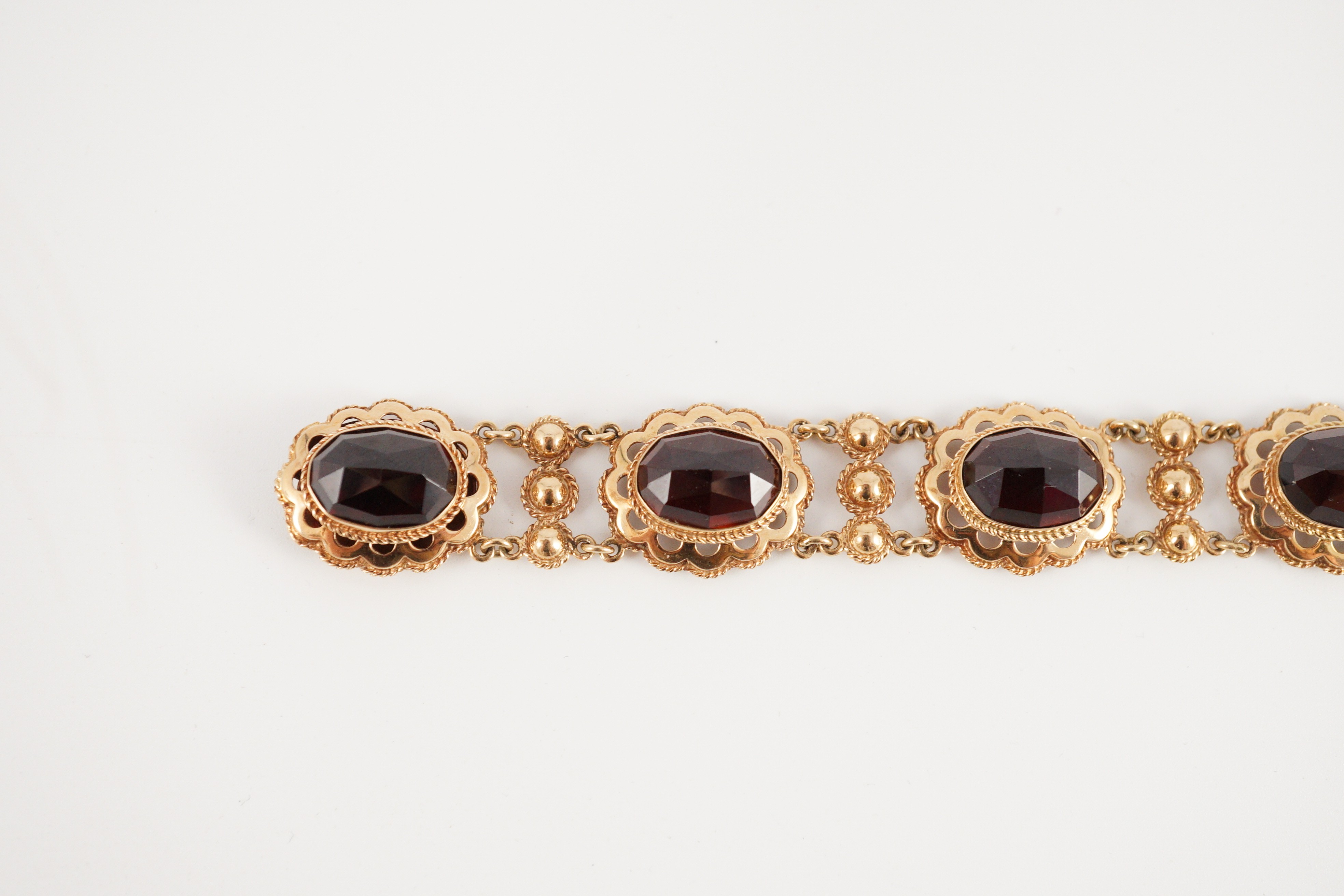 A 20th century Dutch 14k gold and six stone facet cut cabochon garnet set fancy link bracelet